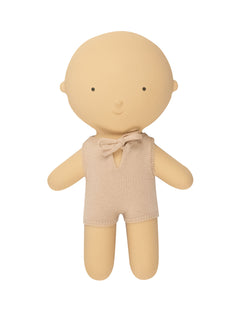 Boneco de borracha com macacão de pano bege e laço no pescoço. we are gommu