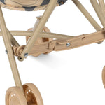 Carrinho de bonecas com estrutura bege e rodas dianteiras. Konges Sløjd