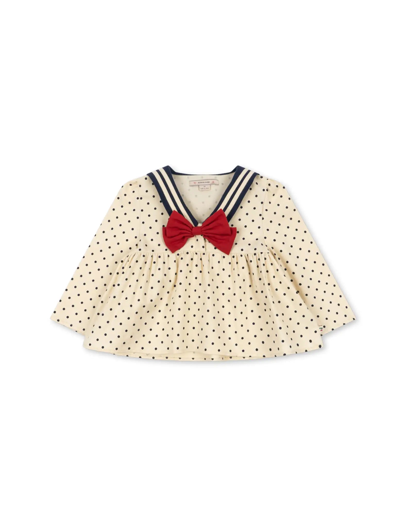 Camisa infantil creme com bolinhas pretas, gola azul-marinho e laço vermelho. Konges Sløjd