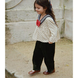 Camisa infantil creme com bolinhas pretas e gola azul-marinho, laço vermelho. Konges Sløjd