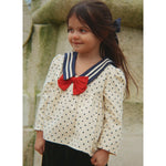 Camisa infantil creme com bolinhas pretas, gola azul-marinho e laço vermelho. Konges Sløjd
